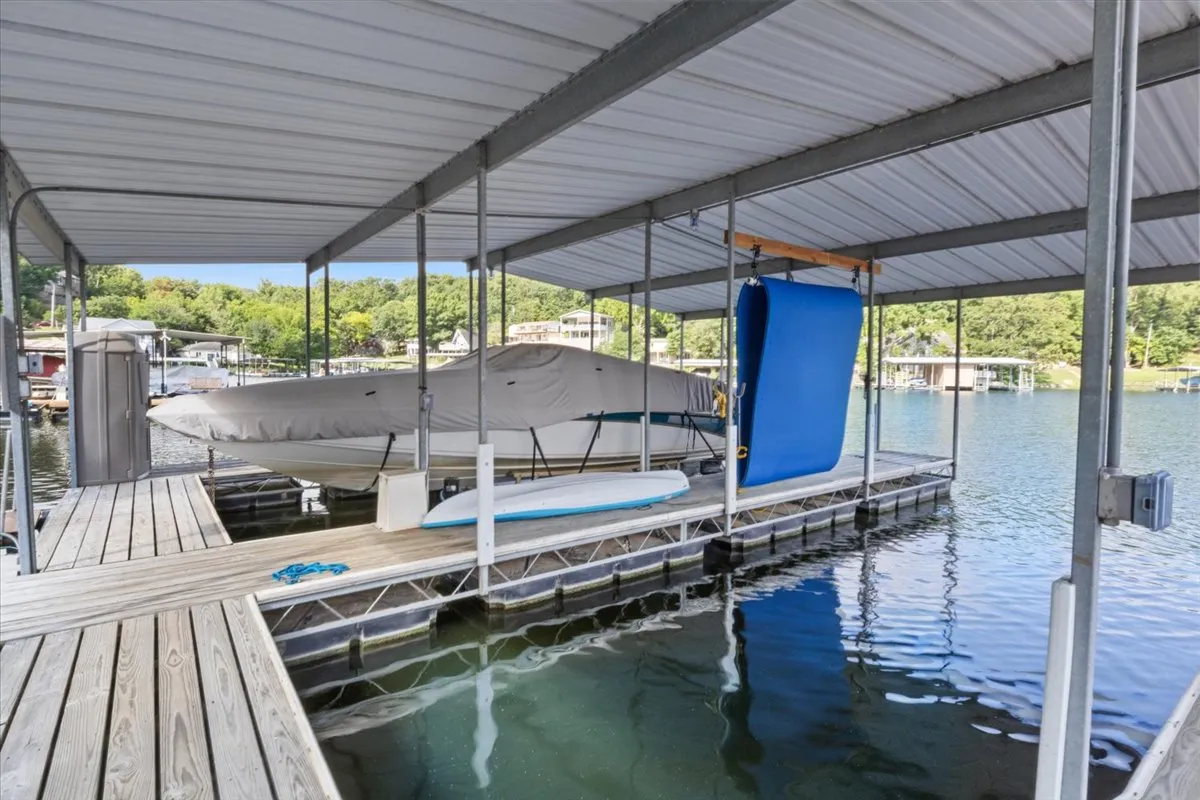 A dock featuring a boat, a floating mat, and the shimmering water surface, ready for boating, fishing, or water sports. The relaxed setting encourages fun and active engagement on the lake.